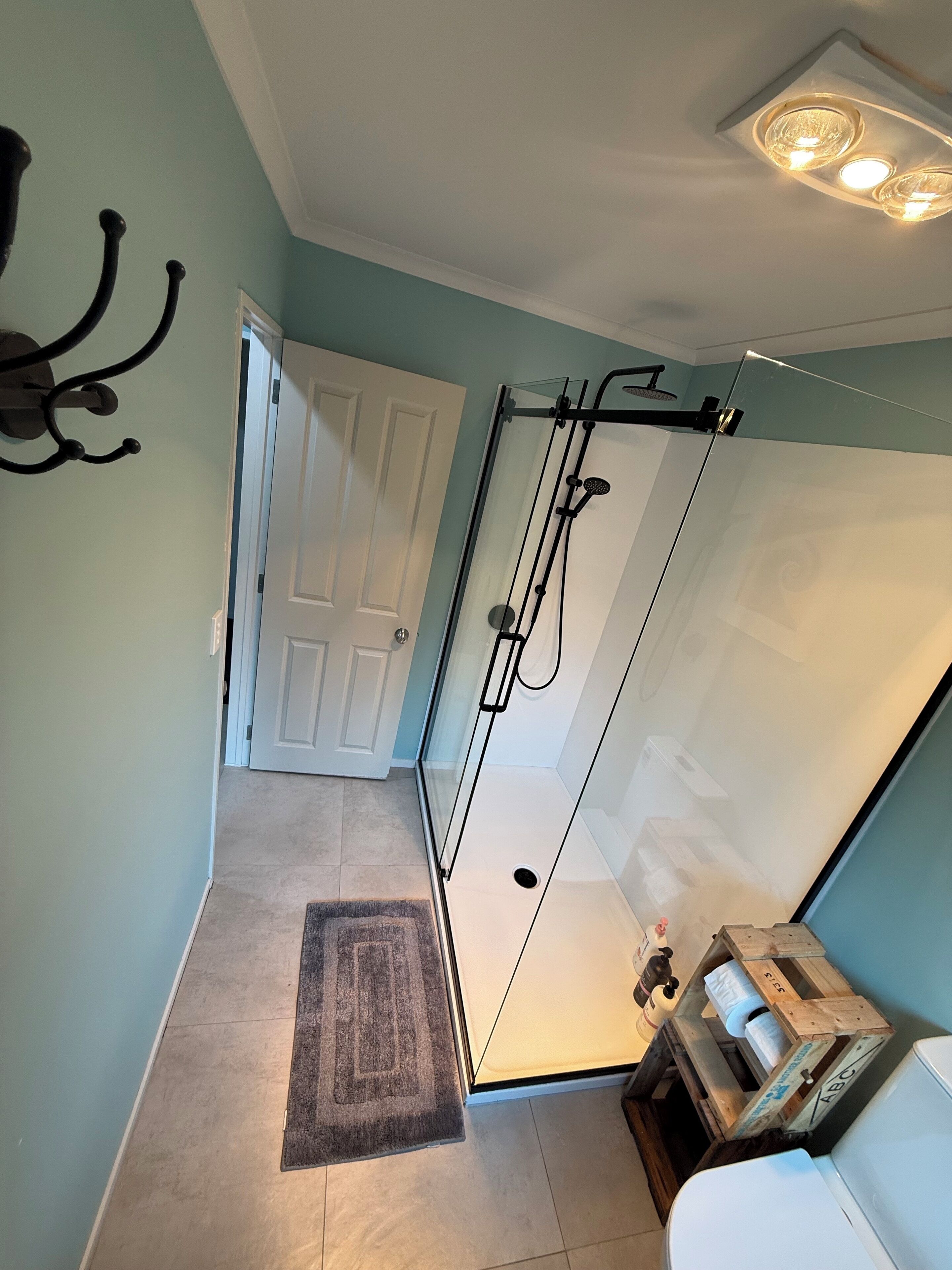 Une salle de bain moderne avec une douche à parois de verre, un porte-serviettes et des toilettes.