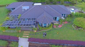 Une grande maison avec un jardin spacieux, une serre et une allée.