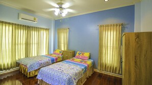 A room with two single beds, a ceiling fan, an air conditioning unit, and a wooden wardrobe. - Baan San Rak By Puppap (Cha-am)