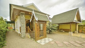 A house with a stone facade, wooden porch, and a checkered pathway leading to the entrance. - Baan San Rak By Puppap (Cha-am)