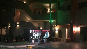 A nighttime view of a building with a sign reading "MARINA CABO PLAZA". - Studio Suite at Marina Cabo Plaza (Cabo San Lucas)