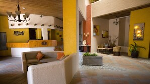 A spacious lobby with a reception desk, comfortable seating areas, and a tiled floor. - Studio Suite at Marina Cabo Plaza (Cabo San Lucas)