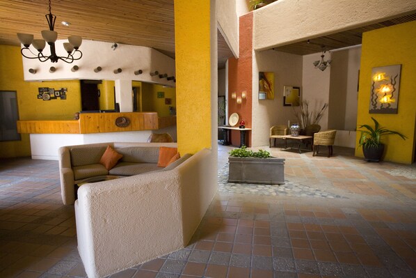 A spacious lobby with a reception desk, comfortable seating areas, and a tiled floor. - Studio Suite at Marina Cabo Plaza (Cabo San Lucas)