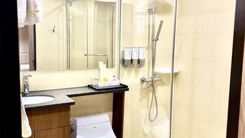 Un baño moderno con inodoro, lavabo y cabina de ducha de vidrio.