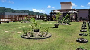 A courtyard with a wooden fence, potted plants, and outdoor seating. - Serenti Hotel (Saipan)
