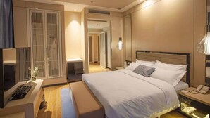 Een moderne hotelkamer met een groot bed, nachtkastjes, een bureau en een kledingkast.