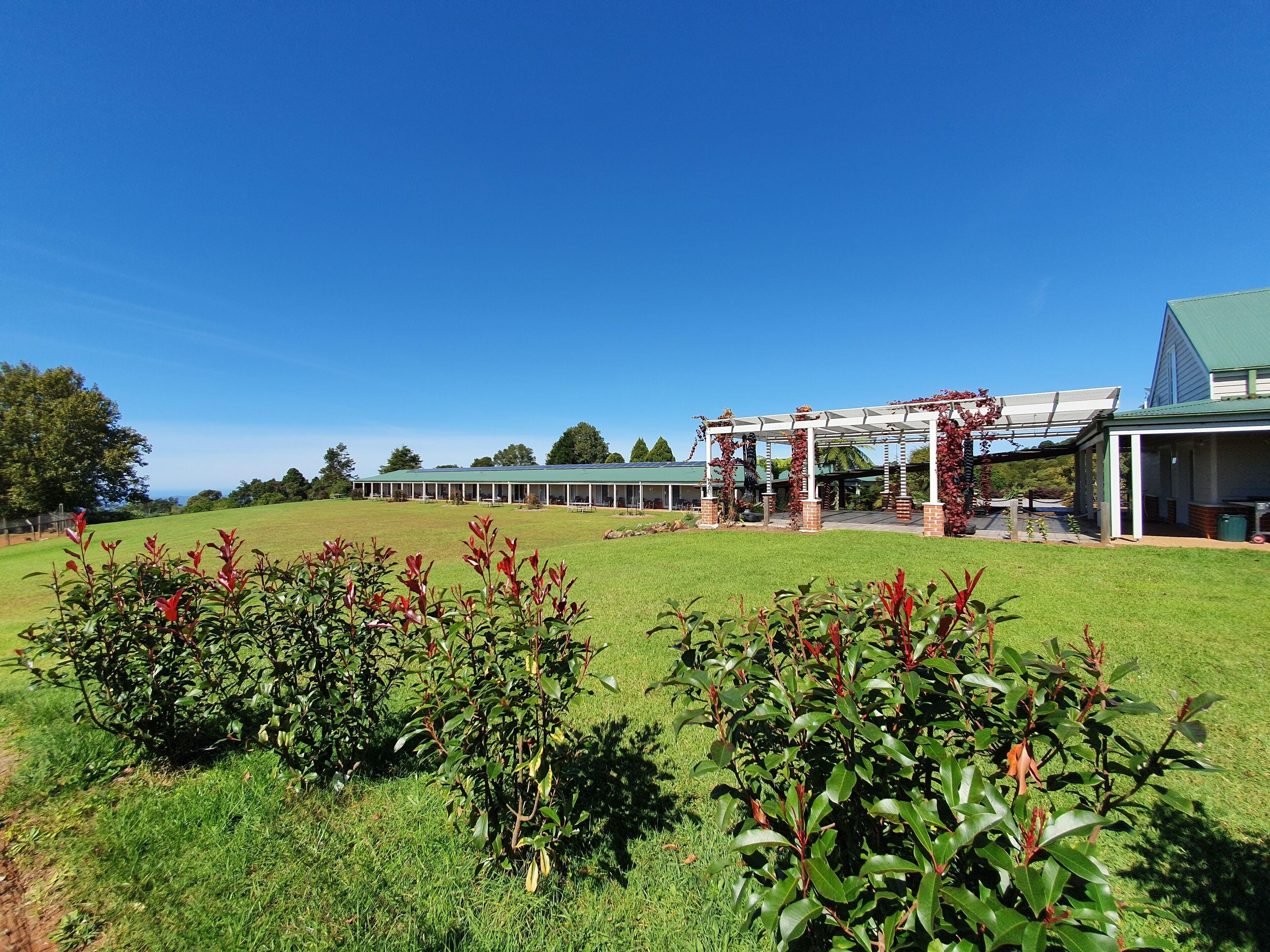 A large building with a covered patio area and a lawn in the foreground.