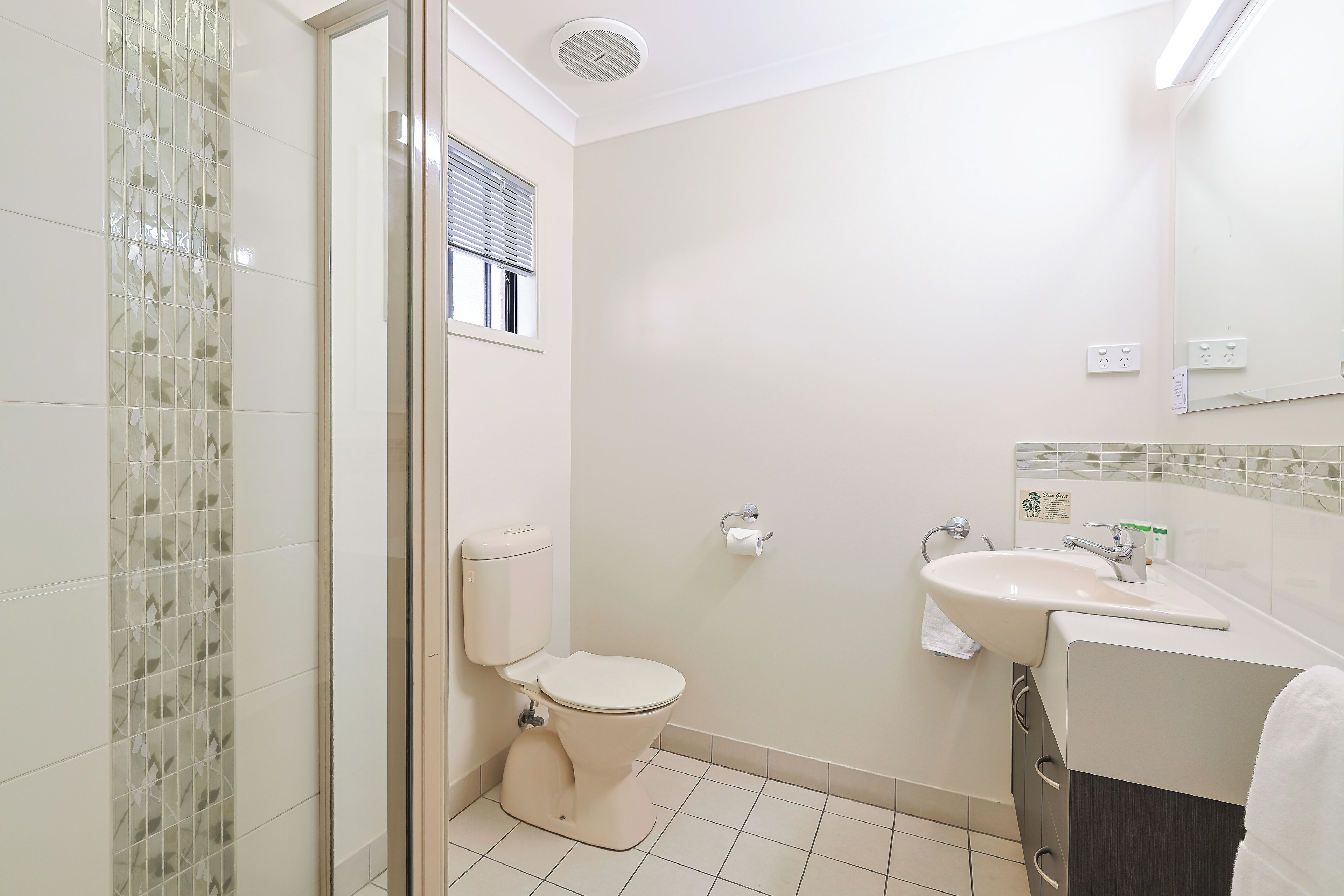 Un baño con inodoro, lavamanos y espejo.