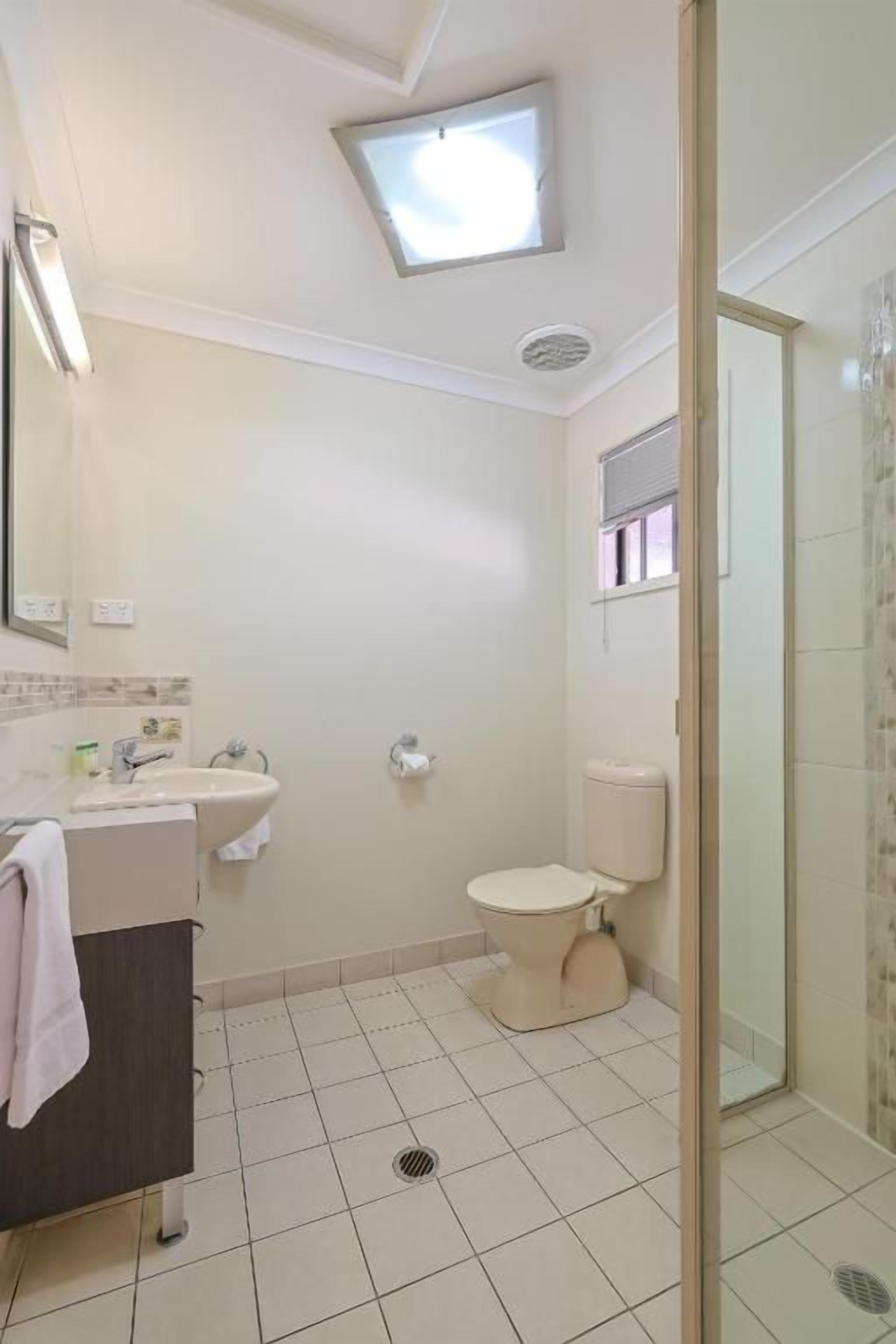 Un baño con inodoro, lavabo y zona de ducha.