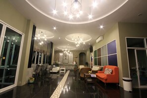 A modern living room with a sofa, chairs, a coffee table, and a decorative lamp. - Na Nicha Bankrut Resort (Bang Saphan)