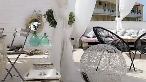 An outdoor seating area with white canopies, a round glass table, and black chairs. - Il Giardino d'Ulisse (Reggio Calabria)