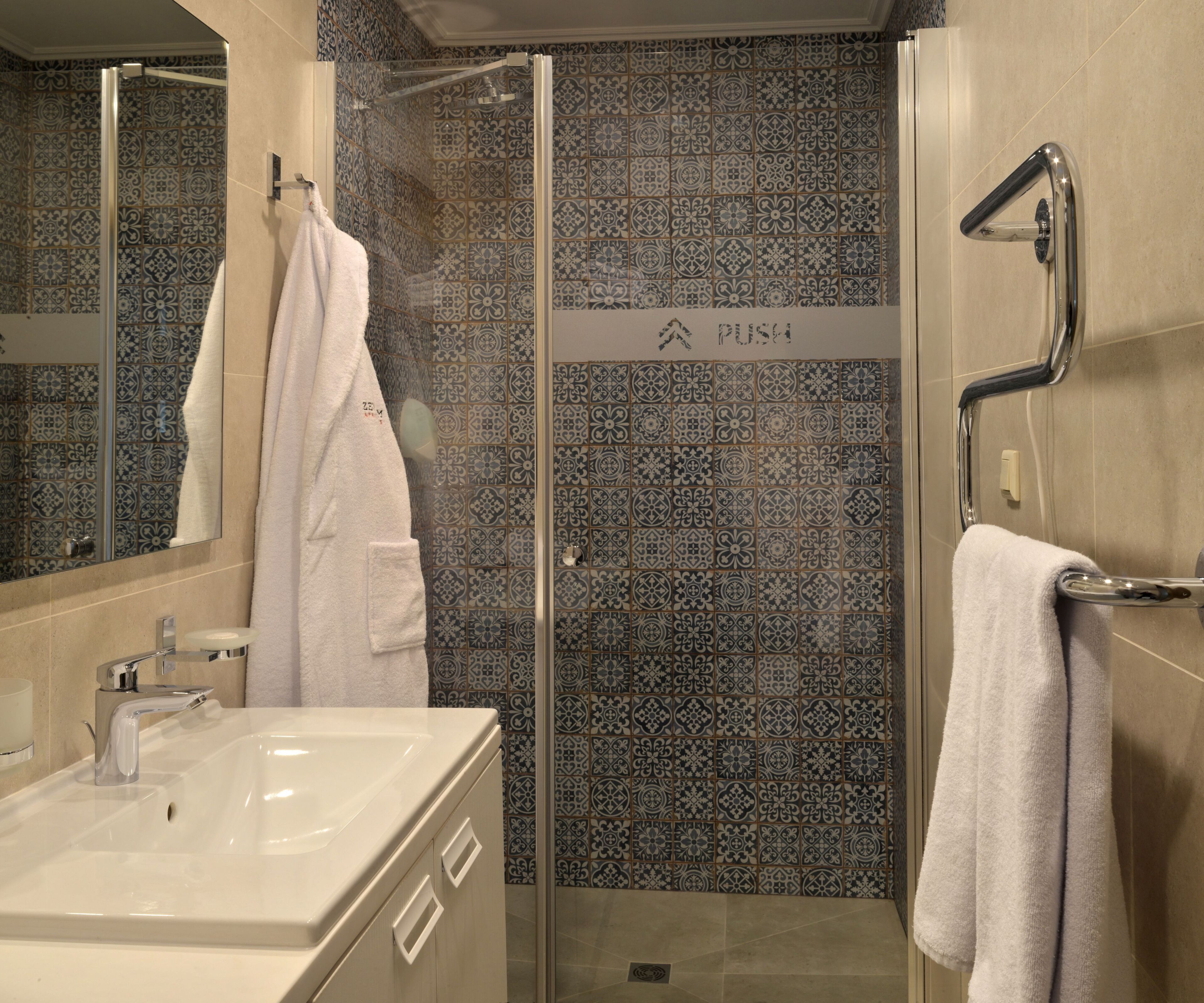 Un baño con ducha, lavamanos y espejo.