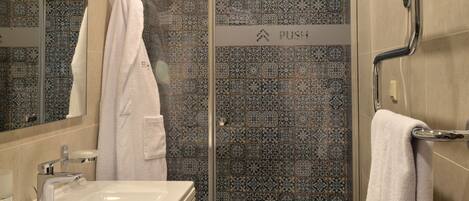 A bathroom with a shower, a sink, and a mirror.