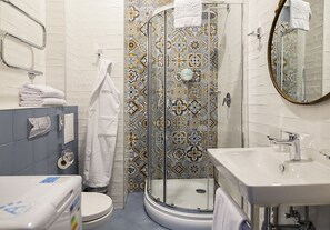 A bathroom with a shower, toilet, sink, and a mirror. - ZENTRUM Hotel (Chisinau)