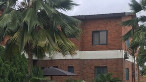 A two-story building with a brick facade and a flat roof. - Joy Family Lodge (Amasaman)