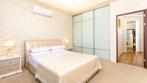 Un dormitorio con cama, mesitas de noche, unidad de aire acondicionado y armario corredero.