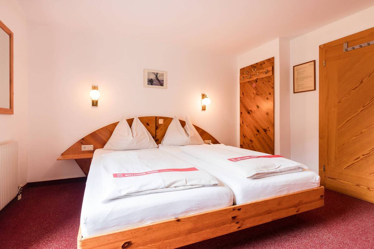 Ein Doppelbett mit Holzschrankgitter, zwei Nachttische und zwei Wandleuchten.