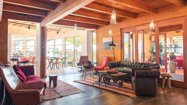 A spacious living area with a wooden ceiling, leather sofas, and a coffee table. - Gut Wenghof - Family Resort Werfenweng (Werfenweng)
