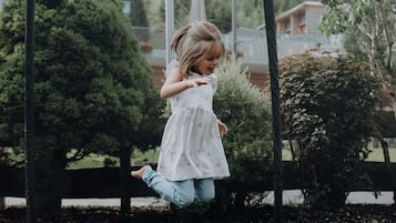 Un niño jugando en un trampolín.