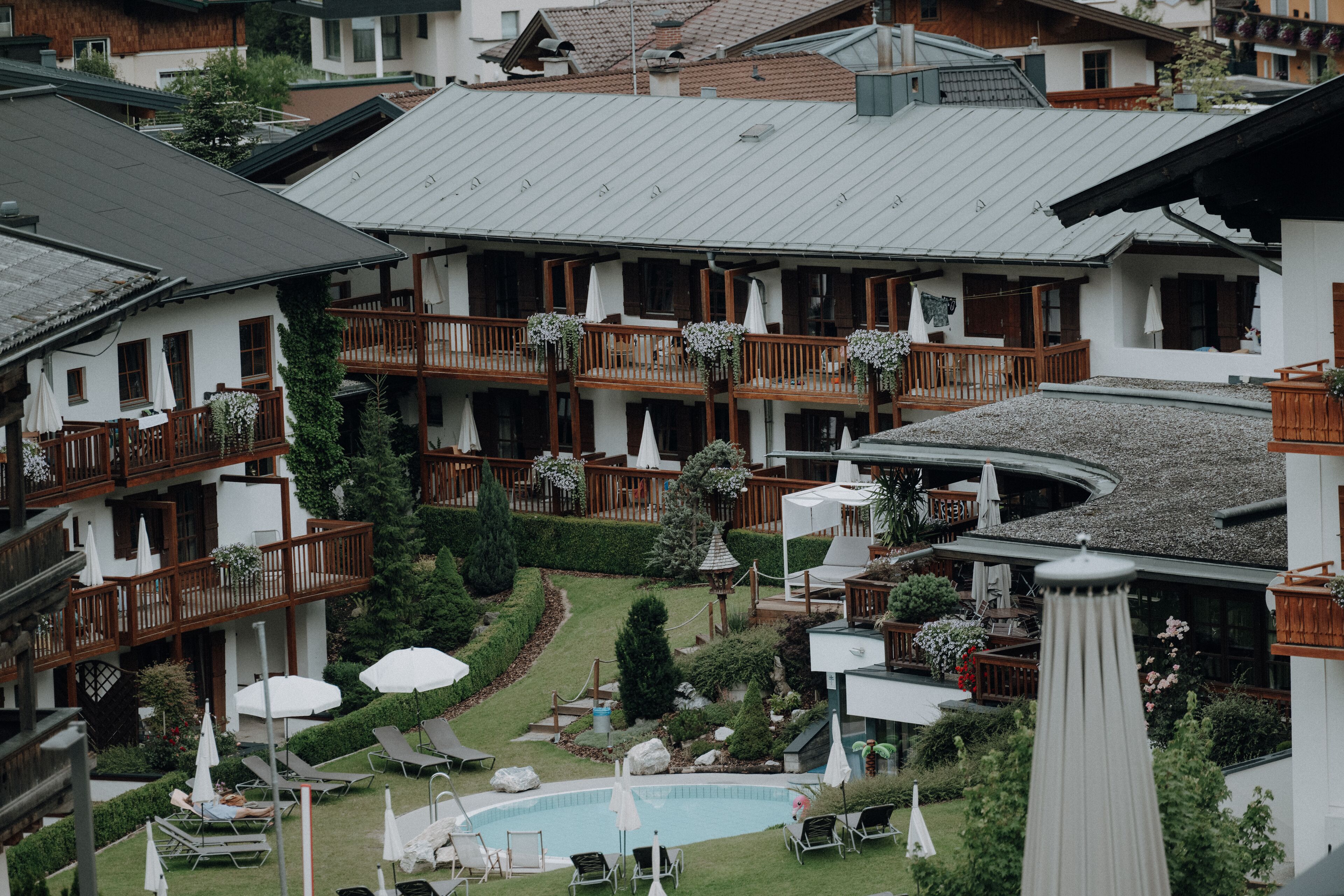 Et hotel med flere altaner, en swimmingpool og udendørs siddeområder.