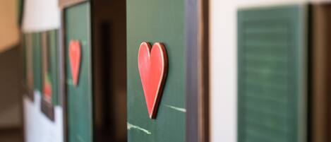 Una hilera de puertas verdes adornadas con corazones rojos.
