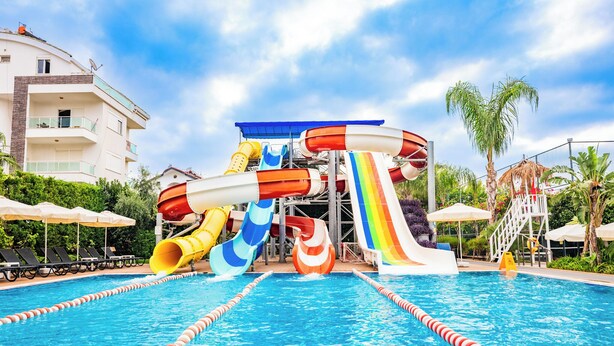 A swimming pool with multiple water slides and lounge chairs. - Calimera Side Resort - All inclusive (Manavgat)
