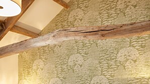 A hotel room with two beds, wooden beams, a floral wallpaper, and bedside lamps. - Kings Head Masham by Chef and Brewer Collection (Ripon)