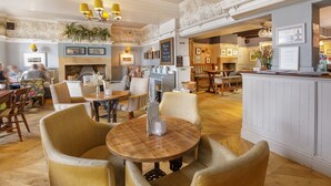 A spacious hotel lobby with wooden flooring, comfortable seating areas, and a central fireplace. - Kings Head Masham by Chef and Brewer Collection (Ripon)