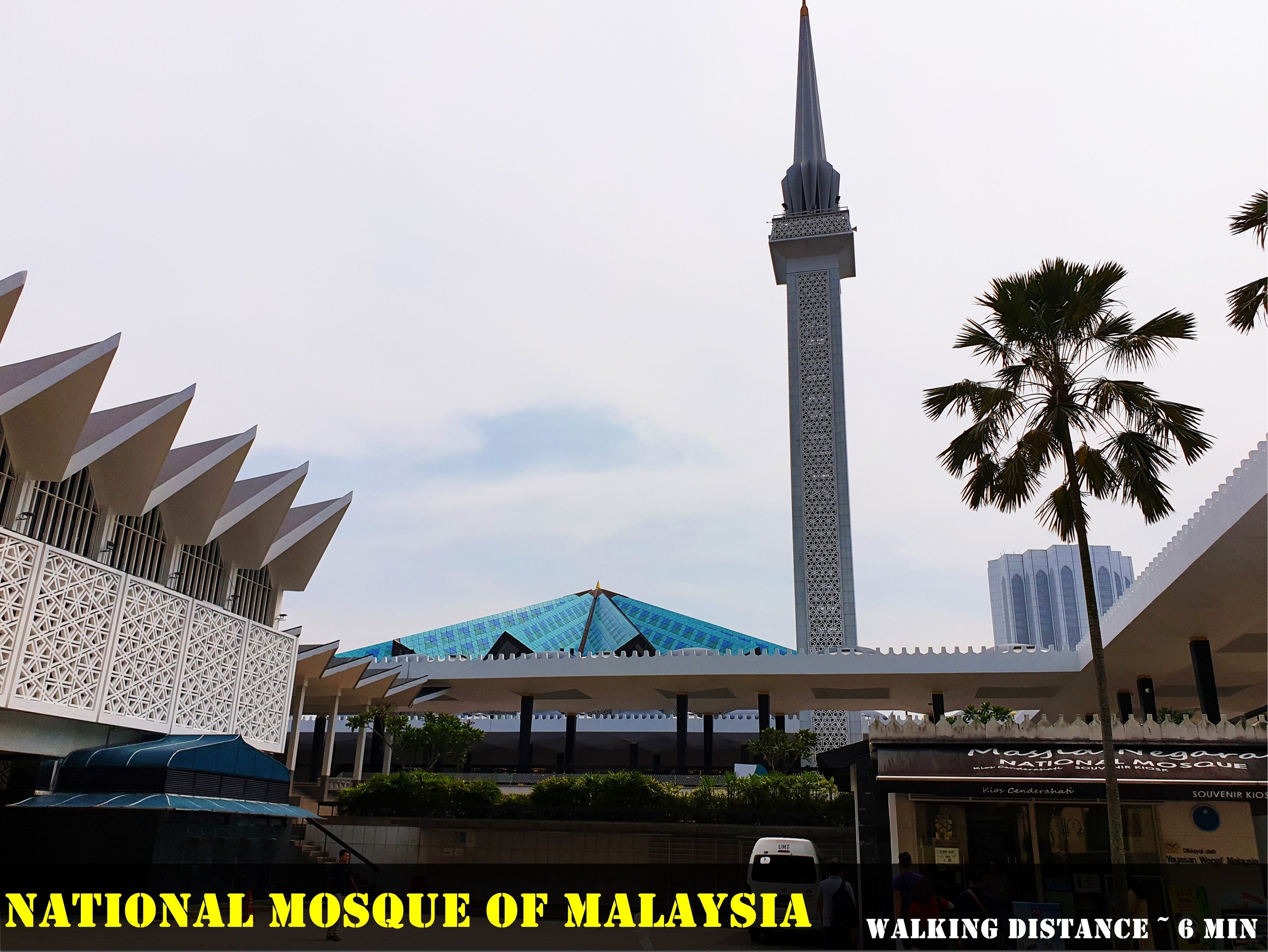 The National Mosque of Malaysia with a prominent minaret, a modern building with geometric patterns, and a walking distance of 6 minutes.