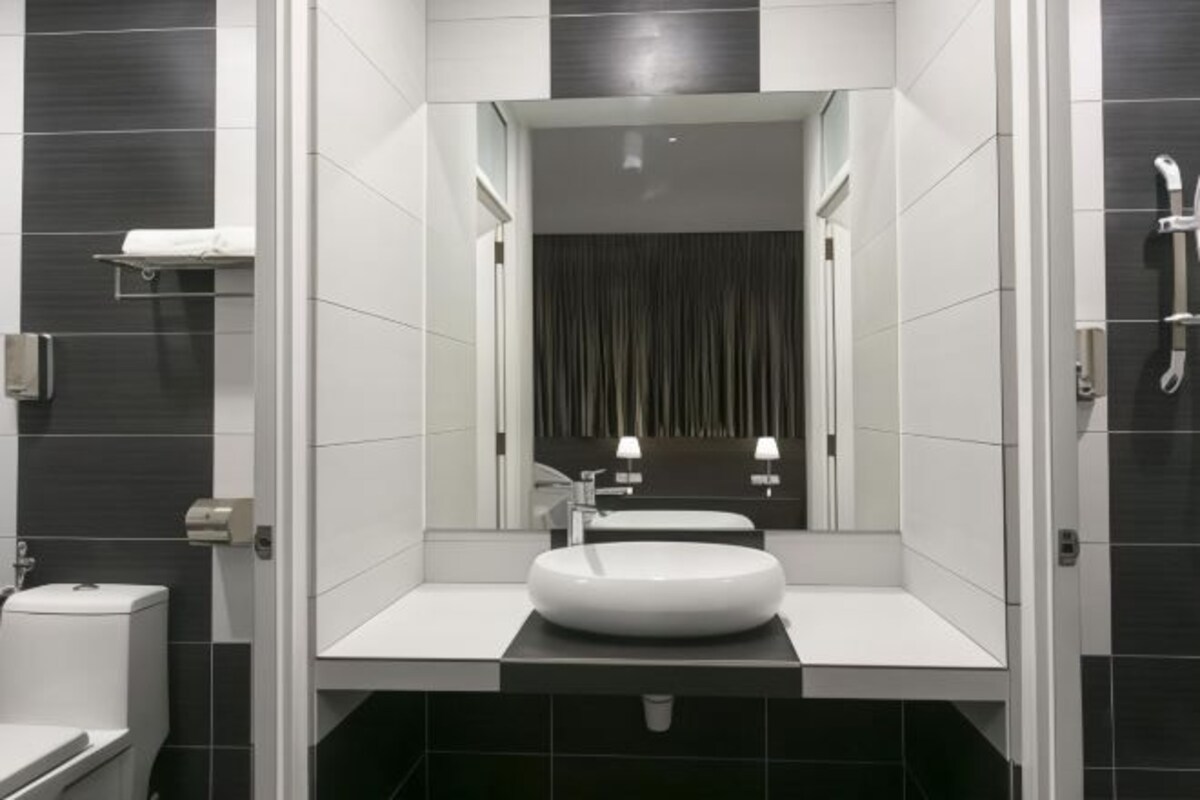 Une salle de bain moderne avec un lavabo rond, un miroir et une douche.