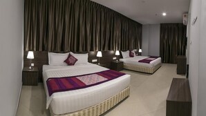 Quarto de hotel com duas camas, cortinas escuras e luminárias laterais.