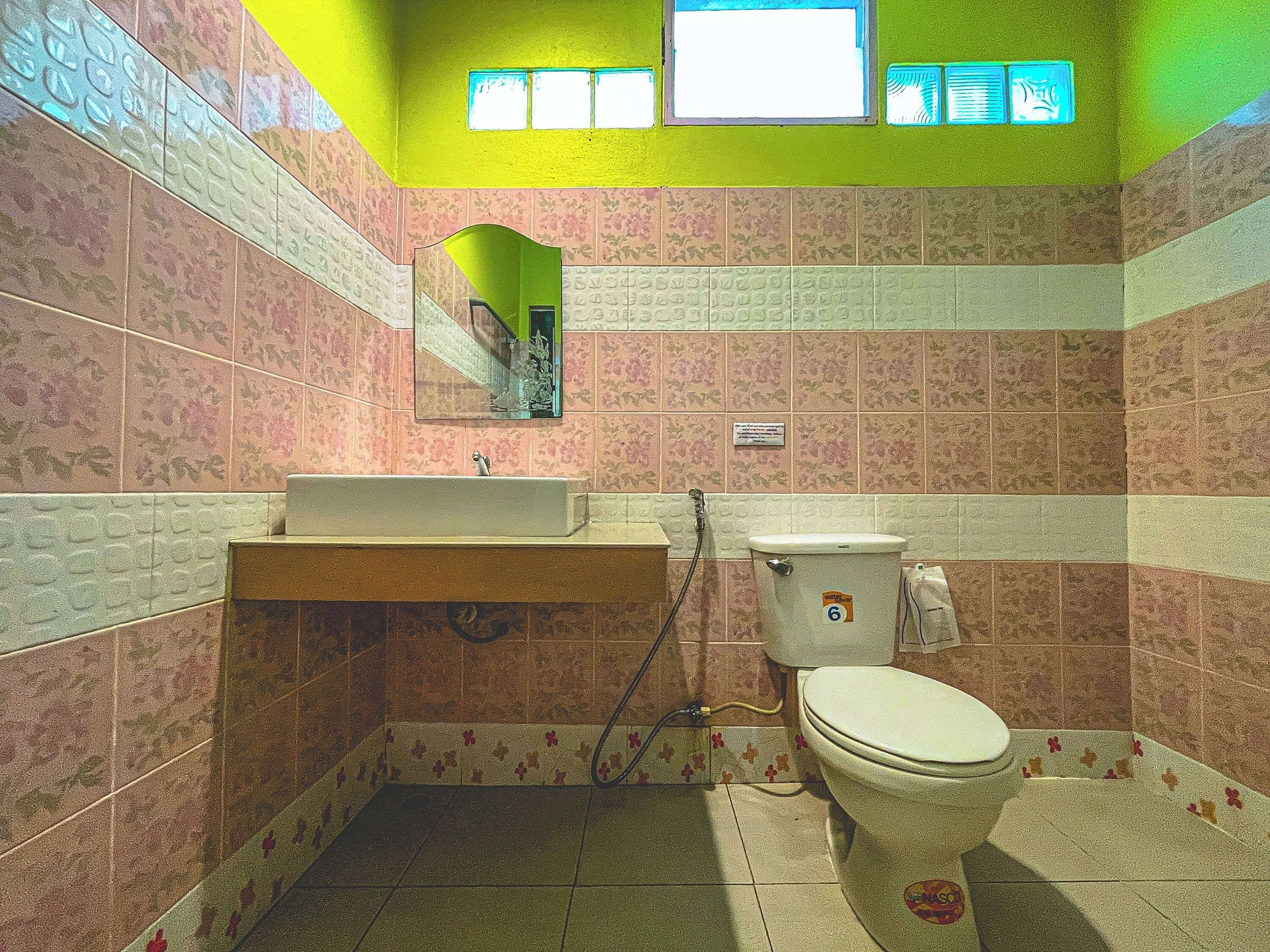 Un baño con lavabo, inodoro y espejo.