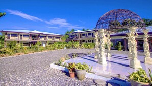 Un hotel con un patio, una cúpula decorativa grande y una zona de piscina.