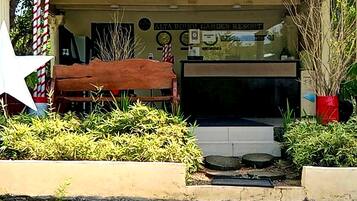 A garden entrance with a bench, potted plants, and a sign for Alta Boon Garden Resort.