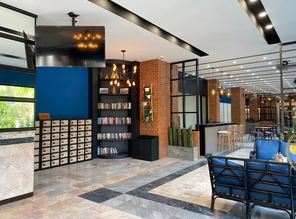 A modern library with bookshelves, a fireplace, and a seating area. - Palette Jomtien Longstay (Pattaya)