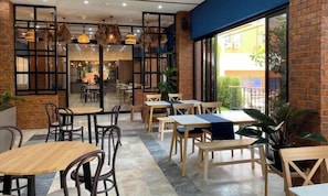 A restaurant with brick walls, wooden tables, and hanging lights. - Palette Jomtien Longstay (Pattaya)