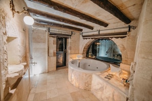 A bathroom with a freestanding bathtub, a large mirror, and a shower enclosure. - Erenbey Cave Hotel (Nevsehir)