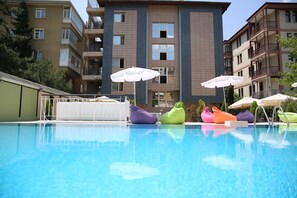 Piscine extérieure, parasols de plage, chaises longues