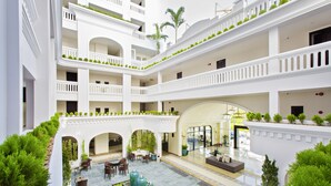 A multi-level courtyard with outdoor seating, greenery, and a central water feature. - Lasenta Boutique Hotel Hoian (Da Nang)
