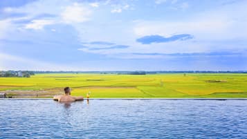 Alberca al aire libre, sombrillas en la alberca y camastros