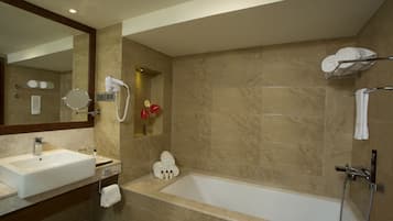 Ein modernes Badezimmer mit großem Waschbecken, Spiegel und Badewanne.