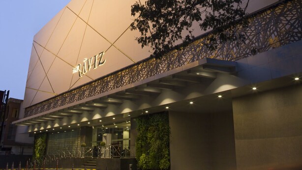 Un edificio moderno con fachada de vidrio y un letrero que dice "NAVIZ".