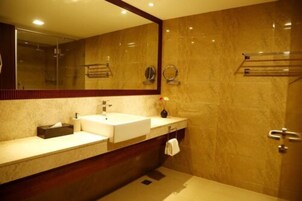 Un baño moderno con dos lavamanos, un espejo grande y un perchero para toallas.