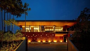 A modern building with a wooden facade and a stone wall at the entrance. - Akanaka (Jakarta)