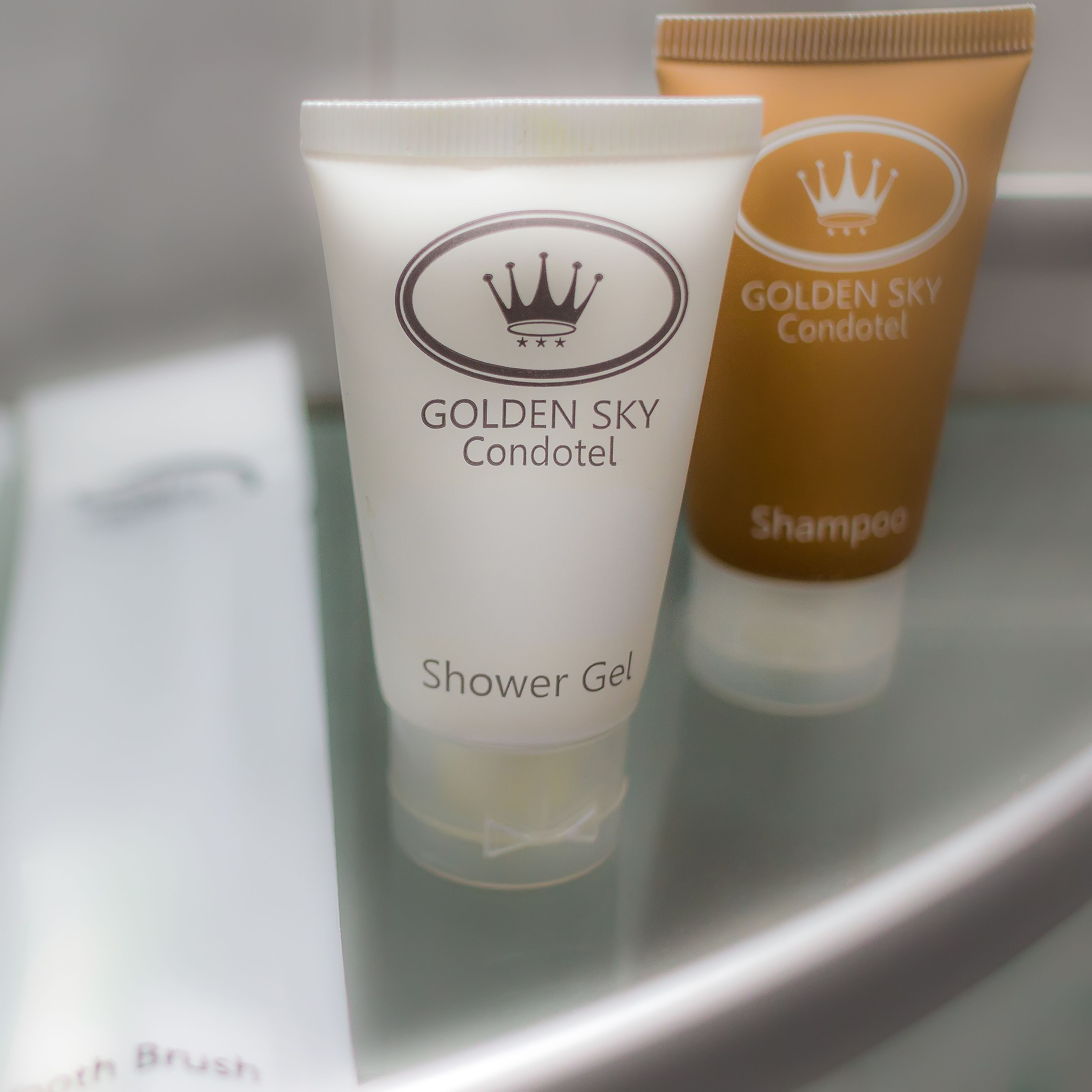 Two toiletries, one labeled 'Golden Sky Condotel Shower Gel' and the other 'Golden Sky Condotel Shampoo'.