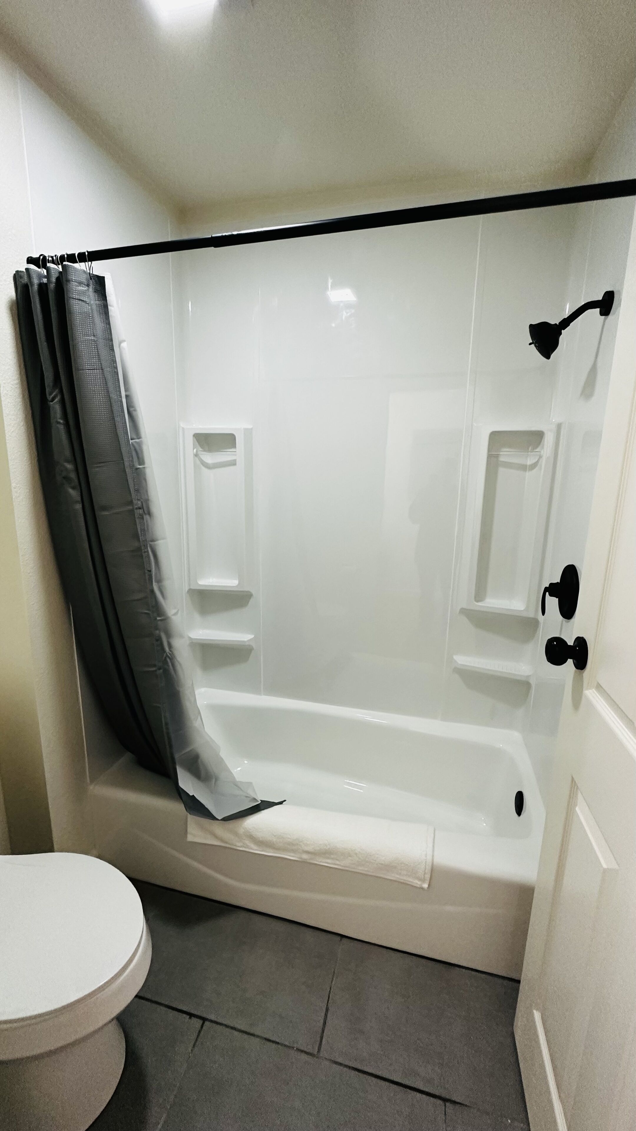A bathroom with a bathtub, a toilet, and a shower curtain.