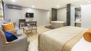 Une chambre d’hôtel comprenant un lit, un canapé, une télévision, un bureau et une salle de bain.