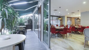 Un restaurant doté d’une terrasse, de grandes fenêtres et d’un décor moderne.