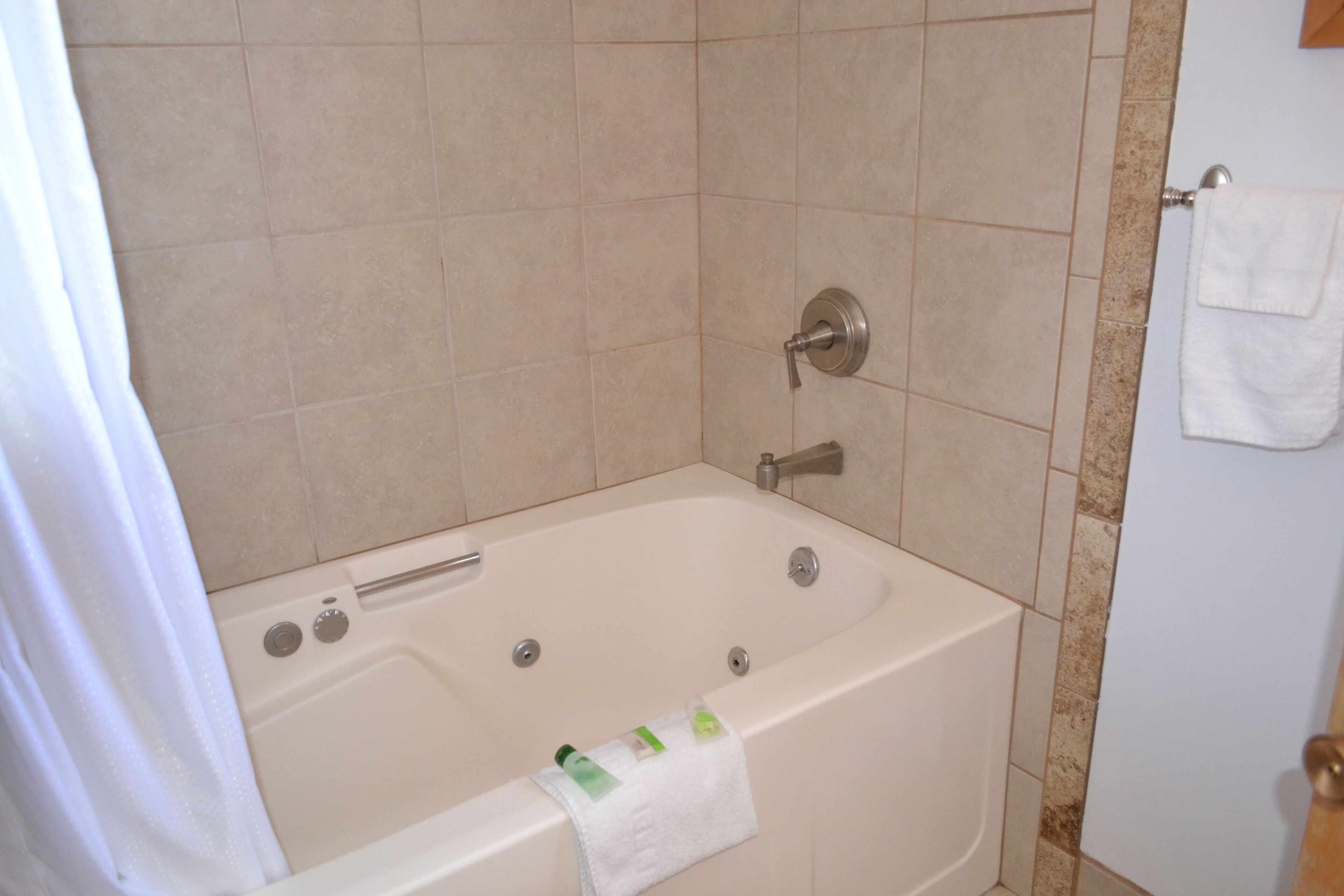 Un baño con bañera, cortina de ducha y barra para toallas.