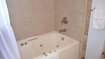 Un baño con bañera, cortina de ducha y barra para toallas.